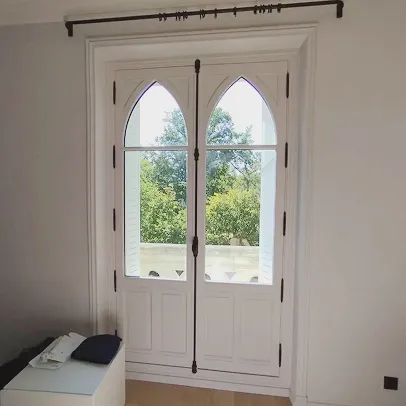 Portes-fenêtres blanches de style gothique avec balcon donnant sur des arbres à Croissy-sur-Seine dans les Yvelines 78