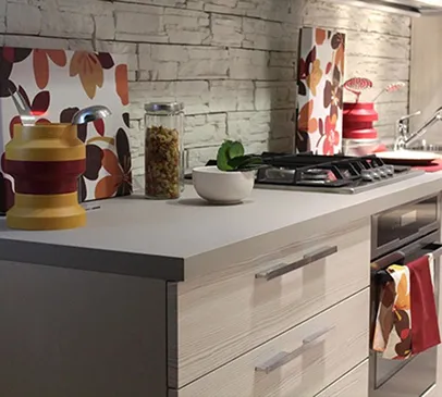 Cuisine moderne avec comptoir gris, murs en briques blanches et objets décoratifs floraux à Croissy-sur-Seine dans les Yvelines 78