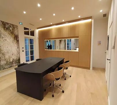 Salle de réunion moderne avec grande table noire, chaises design, et rangement en bois clair à Croissy-sur-Seine dans les Yvelines 78