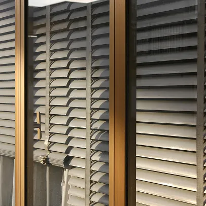 Stores vénitiens gris clairs derrière une fenêtre en verre, avec des cadres bruns à Croissy-sur-Seine dans les Yvelines 78