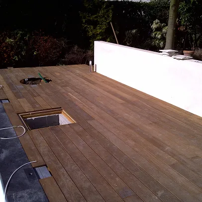 Terrasse en bois en construction avec ouverture carrée et circulaire, mur blanc à Croissy-sur-Seine dans les Yvelines 78