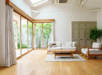 Salon lumineux avec canapé, fauteuil et vue sur un jardin verdoyant à Croissy-sur-Seine dans les Yvelines 78