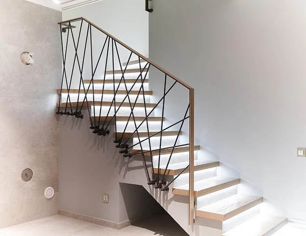 Escalier moderne avec balustrade métallique unique et marches en bois éclairées à Croissy sur Seine dans les Yvelines 78